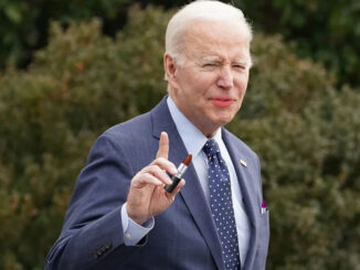 President Biden holding lipstick and wearing lipstick.