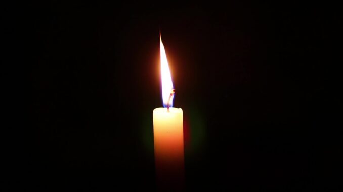 candle burning in darkness