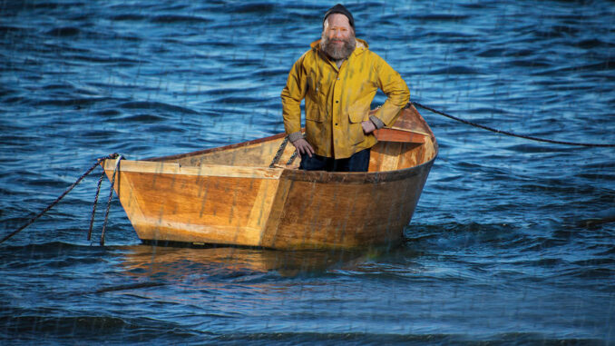 Gene block in fisherman's garb on a small wooden boat